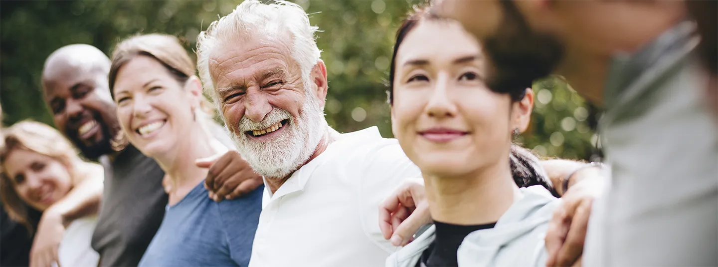Multigenerational, multiethnic group with arms around each other.
