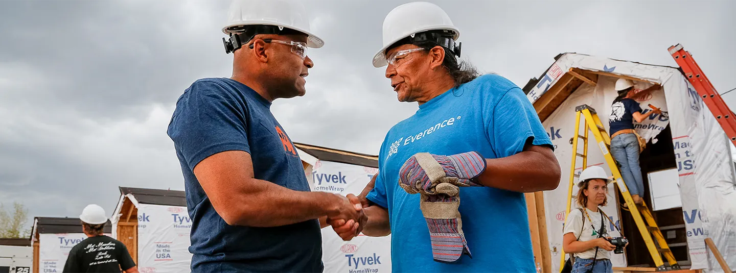 Everence employee and construction worker in front of Tiny House Village.