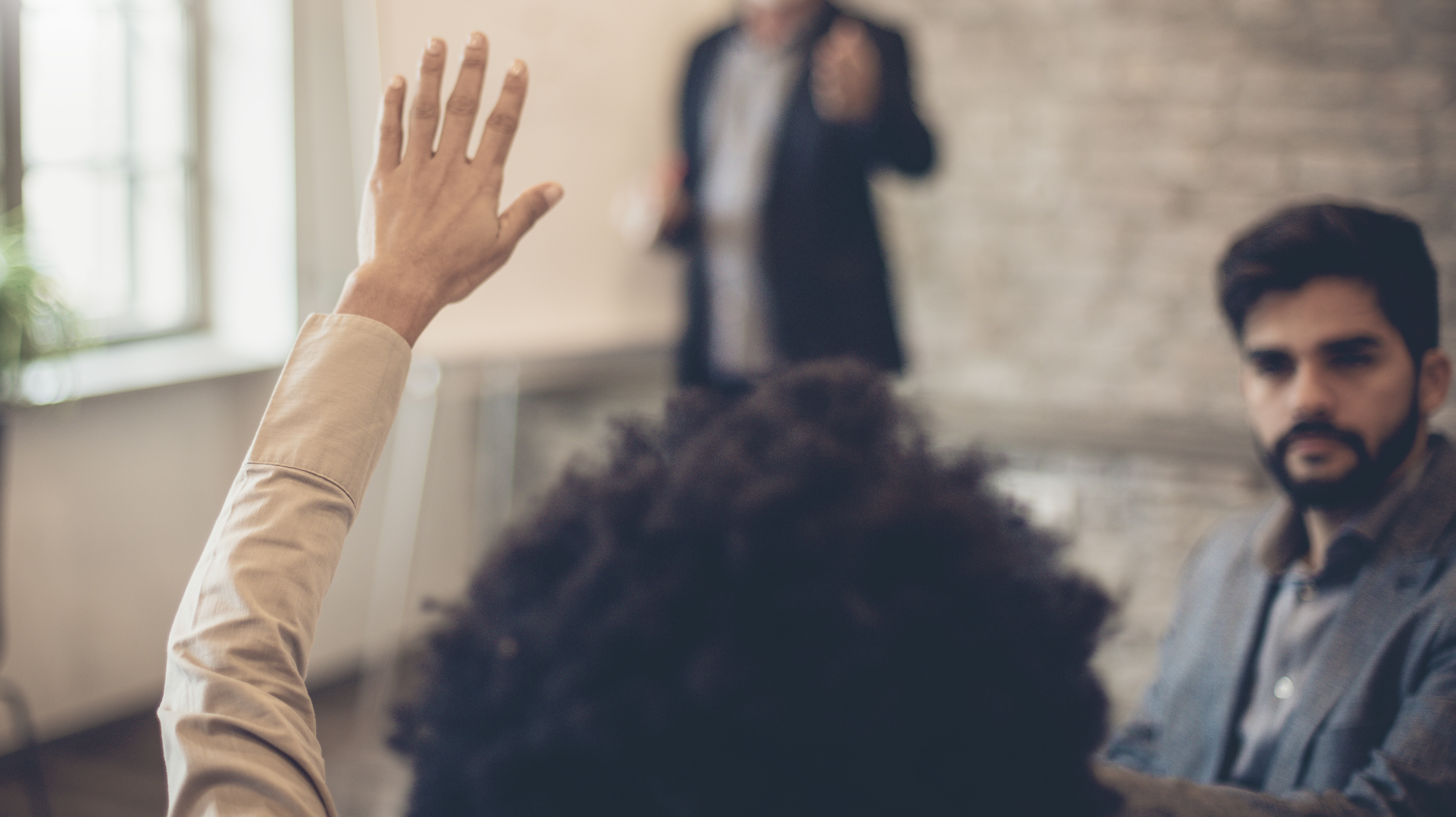 Woman raising her hand in meeting