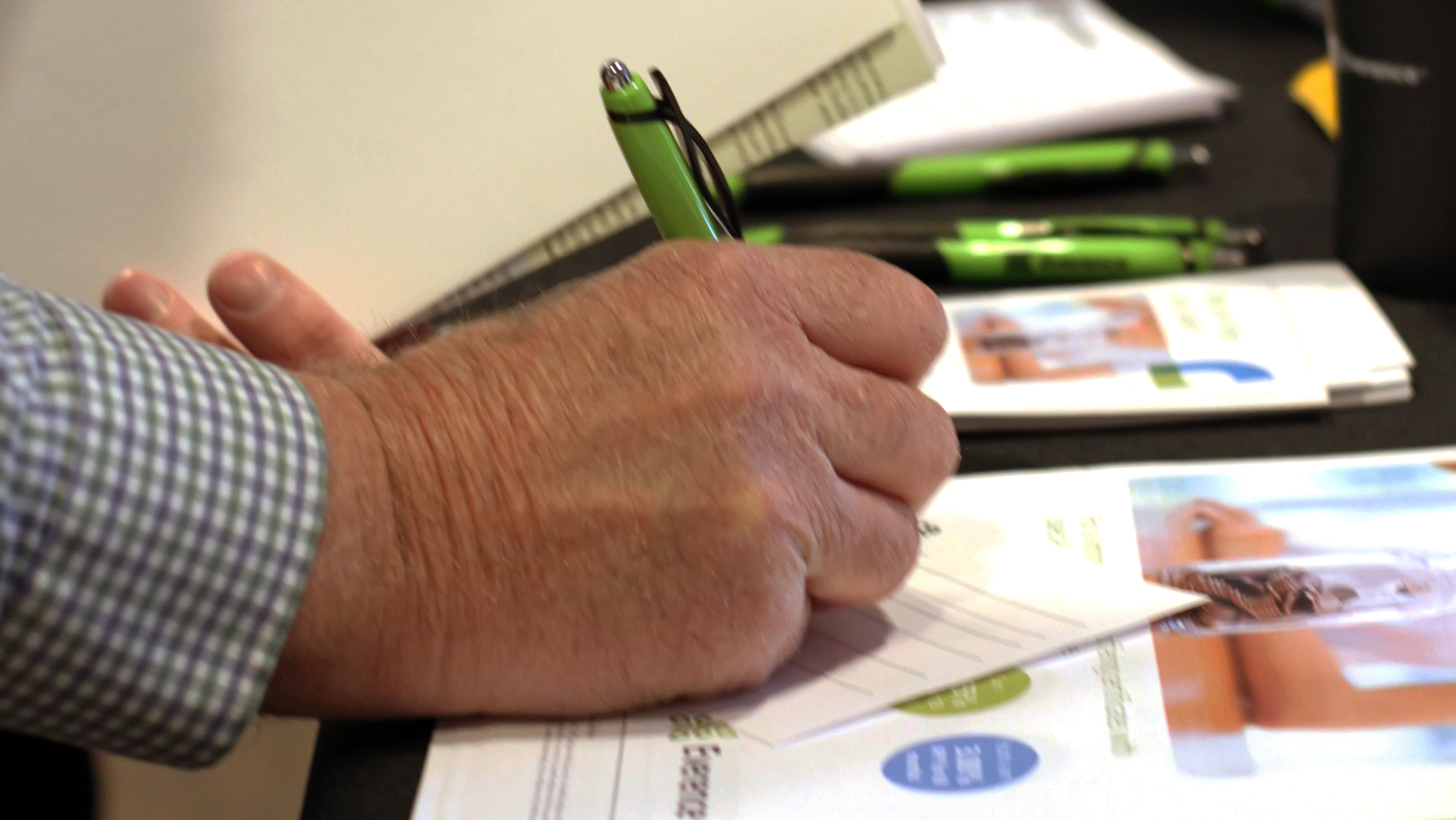 Male hand signing document at Everence event
