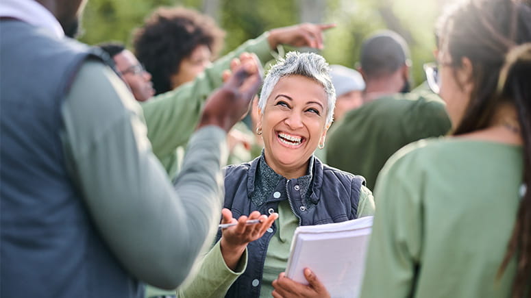 A volunteer leader happily instructs arriving volunteers