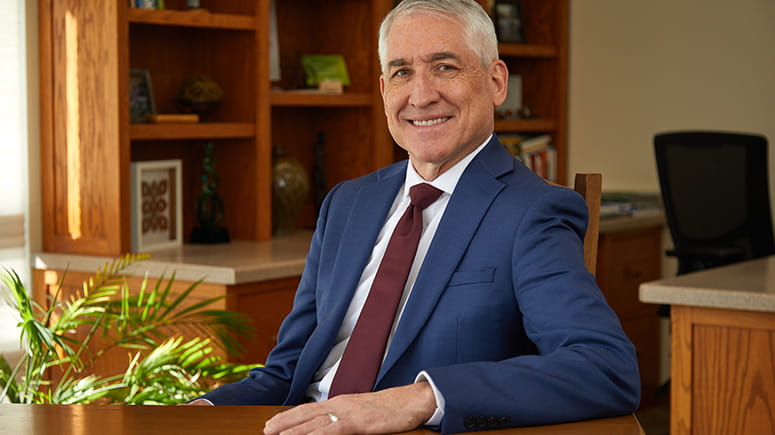 Ken Hochstetler, Everence President, smiles and poses at his desk.