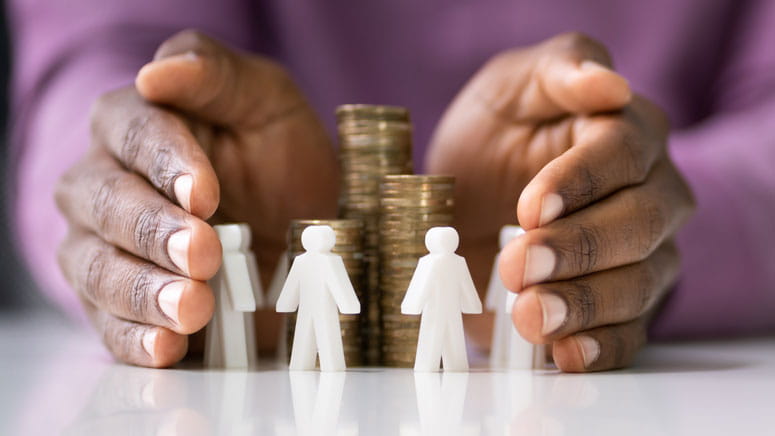 Hands around plastic people surrounding coins