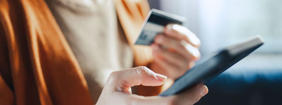 hand holding phone and debit card
