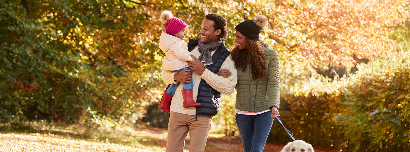 Family walking dog in fall
