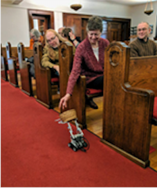 Robot passing the offering plate through pews