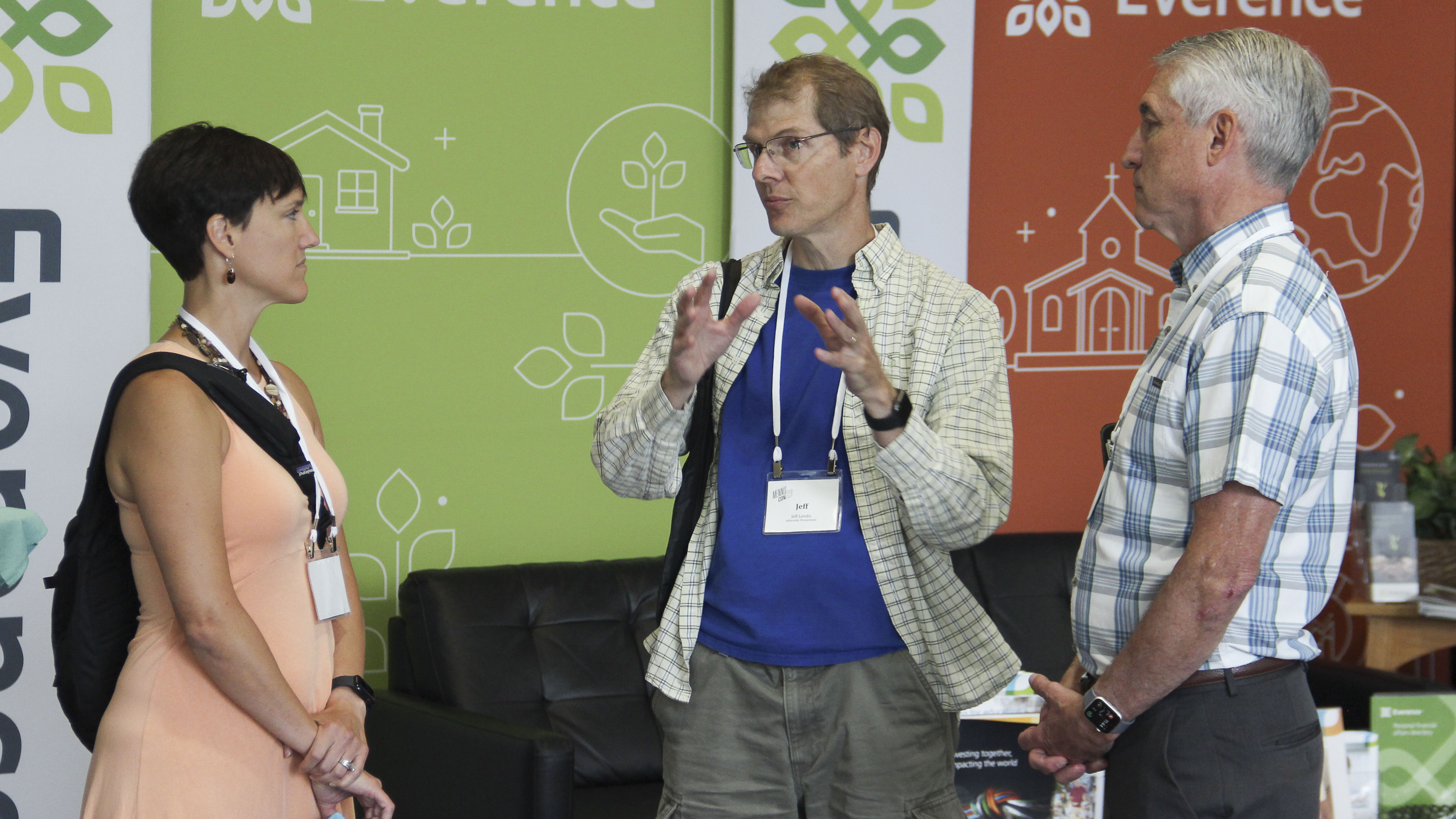 Ken Hochstetler, Everence President and CEO (right), talks with two visitors to the Everence booth at MennoCon23.