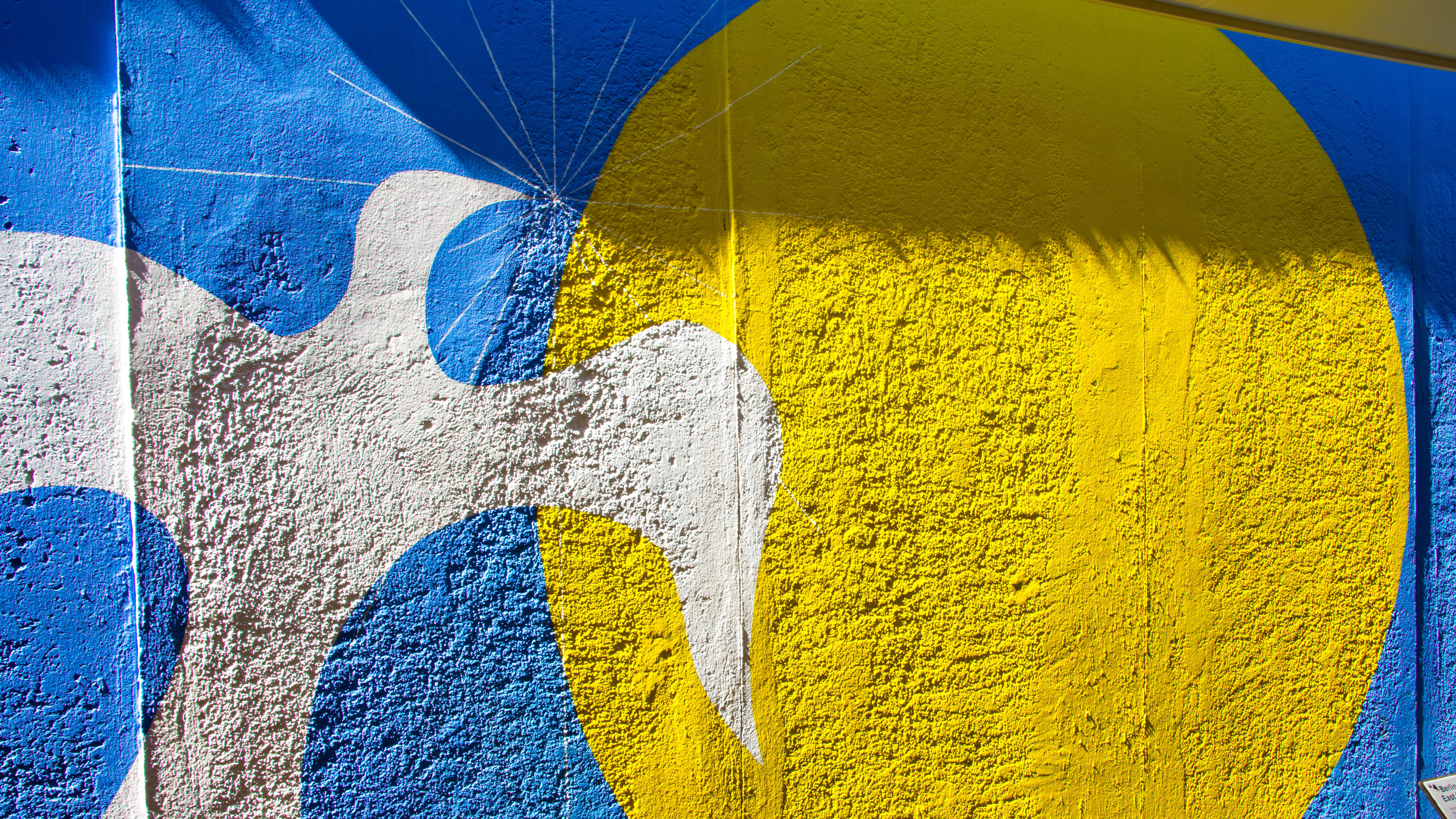Wall with peace dove and sun painted on it, signifying peace for Ukraine