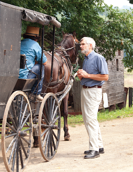 Man talking with people stopped sitting in a horse and buggy