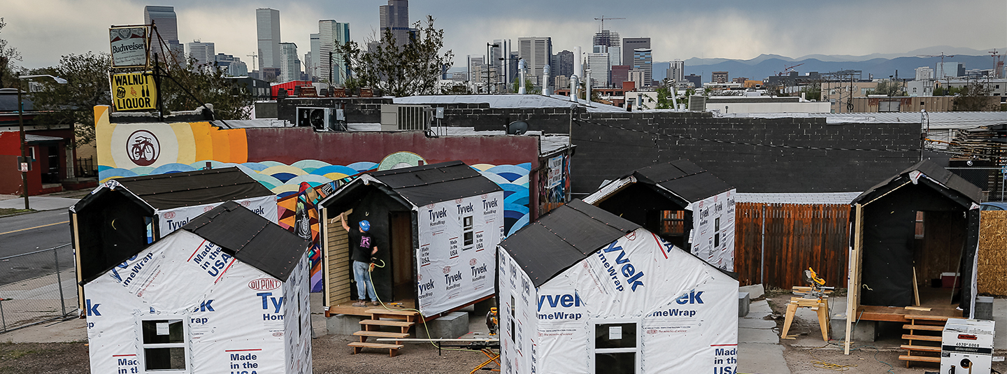 Denver skyline behind tiny house village