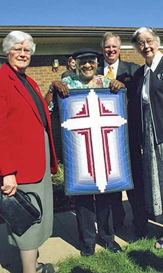 Group holding a framed picture of the cross