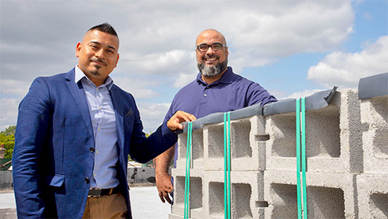 Associate Pastor Sergio Nava and Senior Pastor Esdras Ferreras stand with construction materials for their new church.