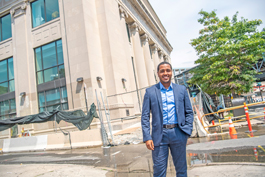 Kevin Gil Financial Wellness Manager stands smiling in front of new Everence office in Philly