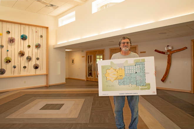 Dana Miller of Dana Miller Building Solutions poses with blueprints of Assembly Mennonite Church
