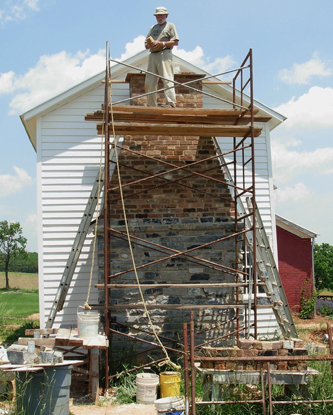 man doing masonry work on a chimney