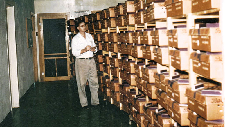 A man walking down a room lined with boxes