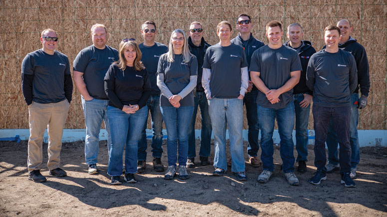 A group of people poses and smiles for the camera in a group photo
