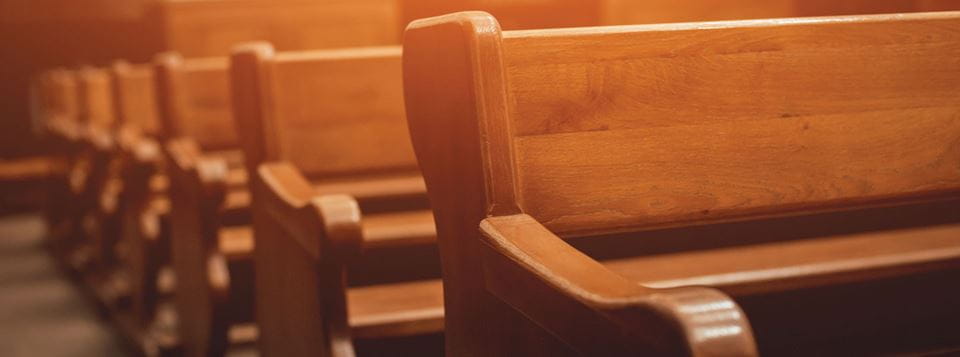 A closeup photo of a row of pews