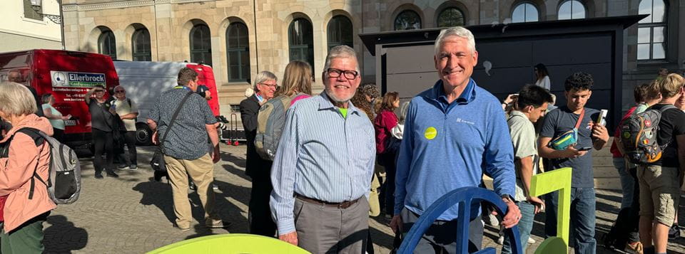 Two men, smiling, pose for a photo