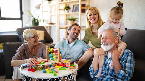 A multigenerational family shares love and laughter in the living room.