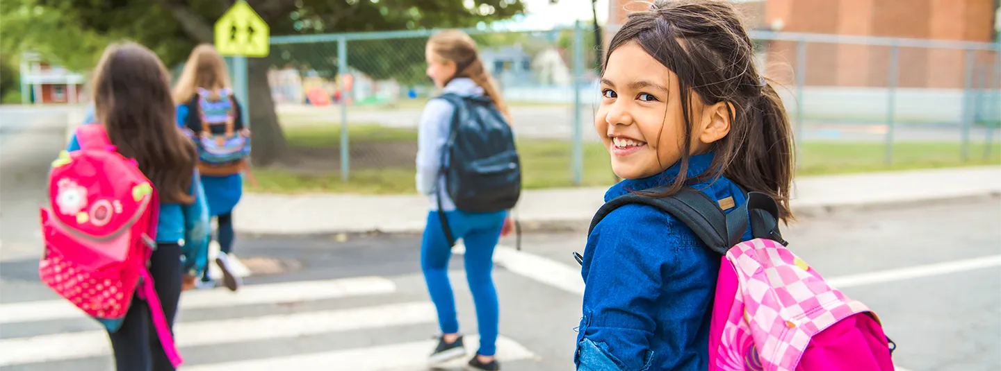 Children crossing the street to school with backpacks