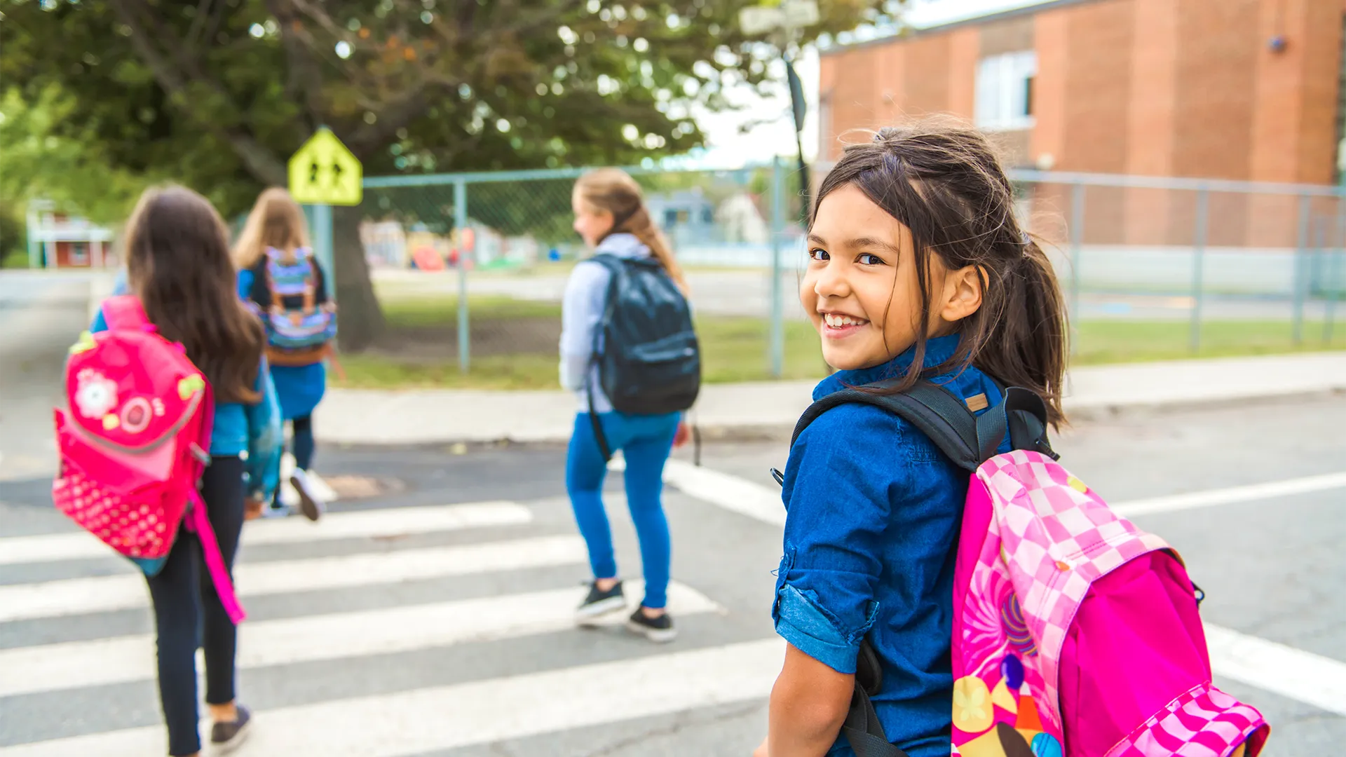 Children crossing the street to school with backpacks
