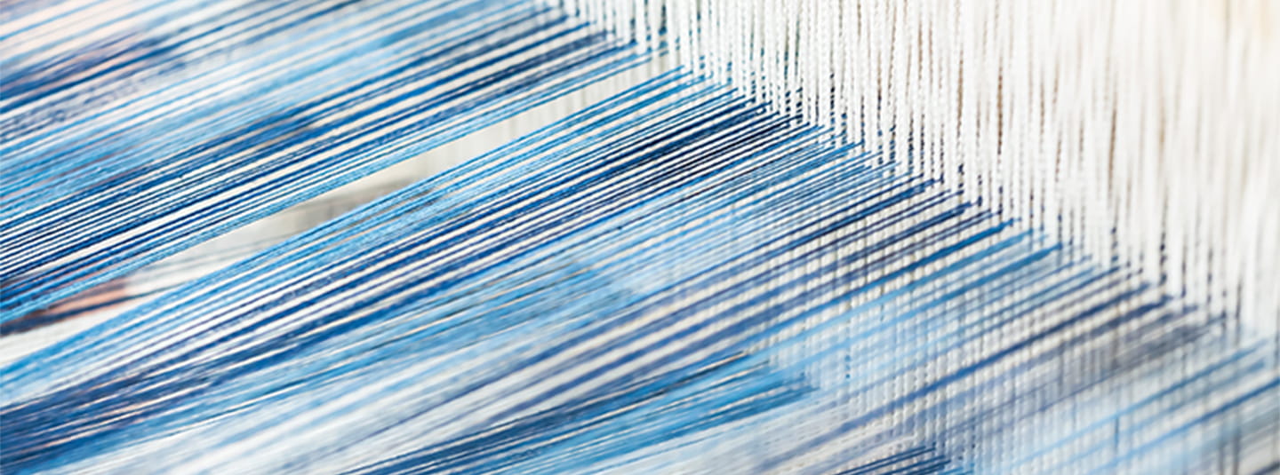 Blue thread being woven in loom
