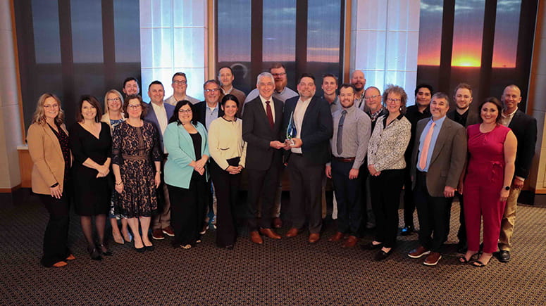 Michiana, team growth award, poses for a photo with their award.