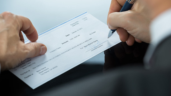 Close up of man writing a check