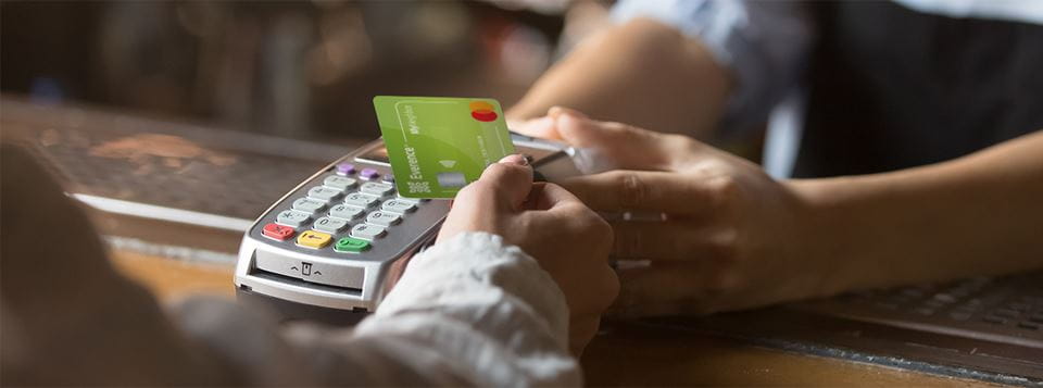 Person using their MyNeighbor credit card to make a purchase with a card reader at a store.