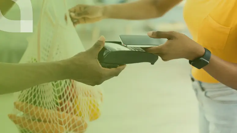Tap to pay being used to buy groceries in a reusable bag.