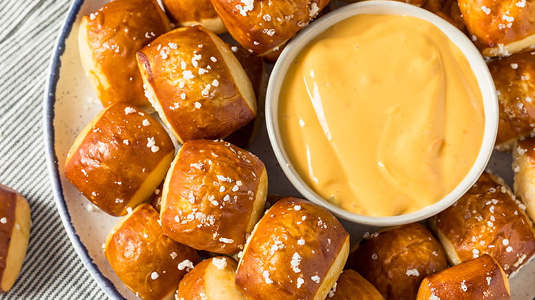Pretzel bites on a plate with dipping cheese
