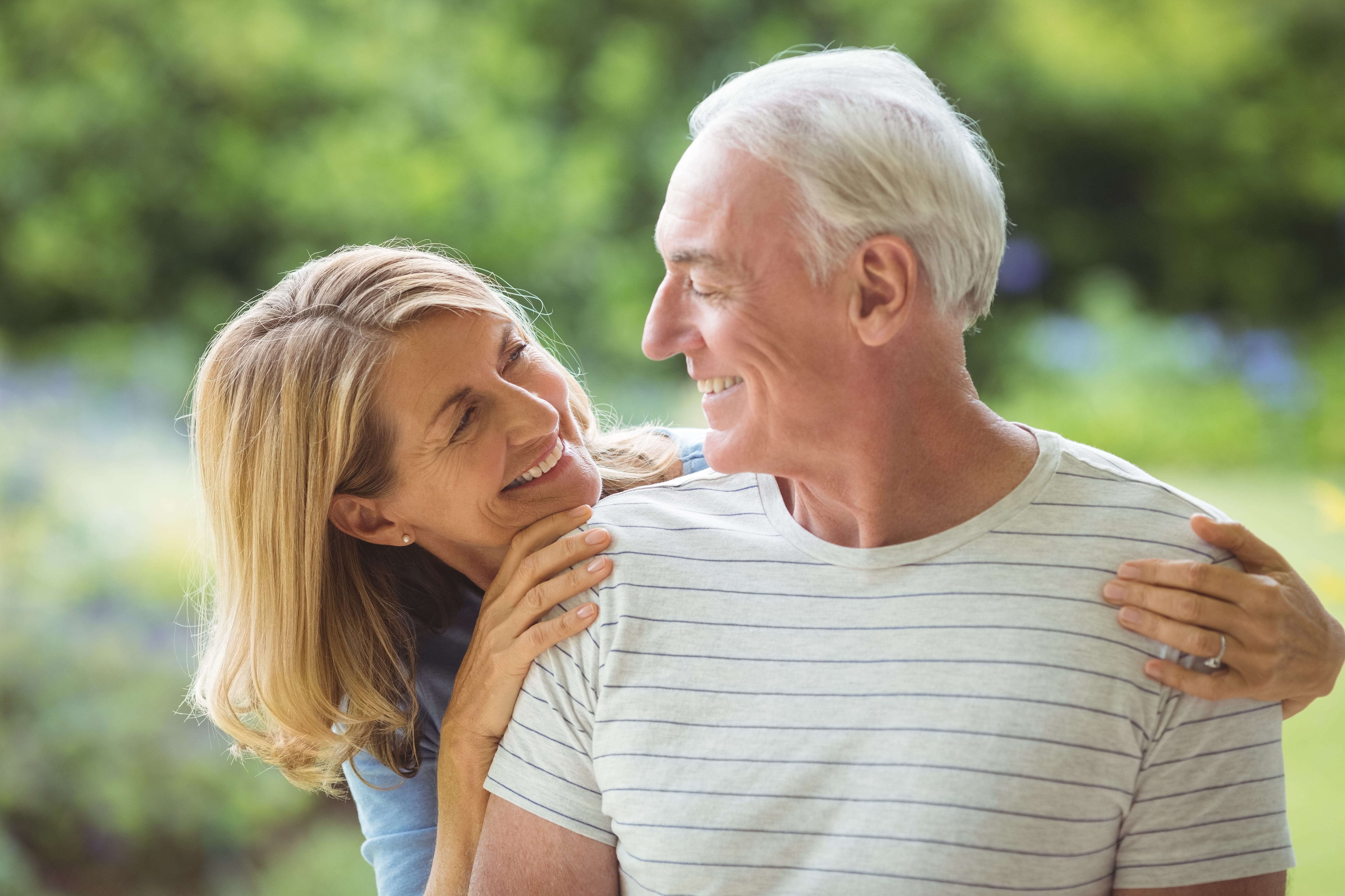 Middle-aged couple look at each other and smile.