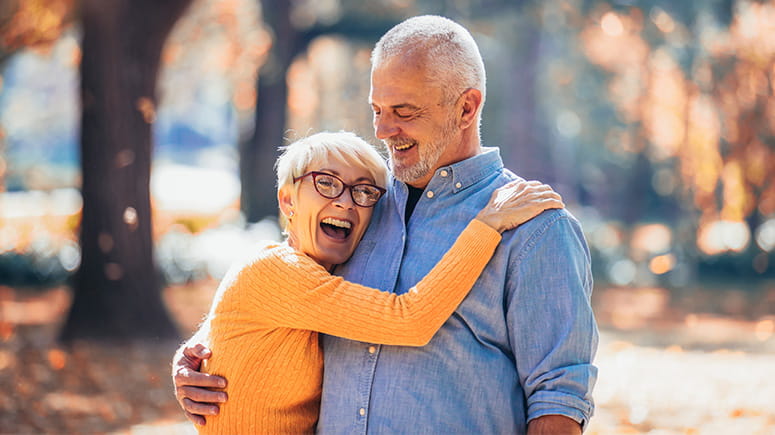 Senior couple hugging in the fall.