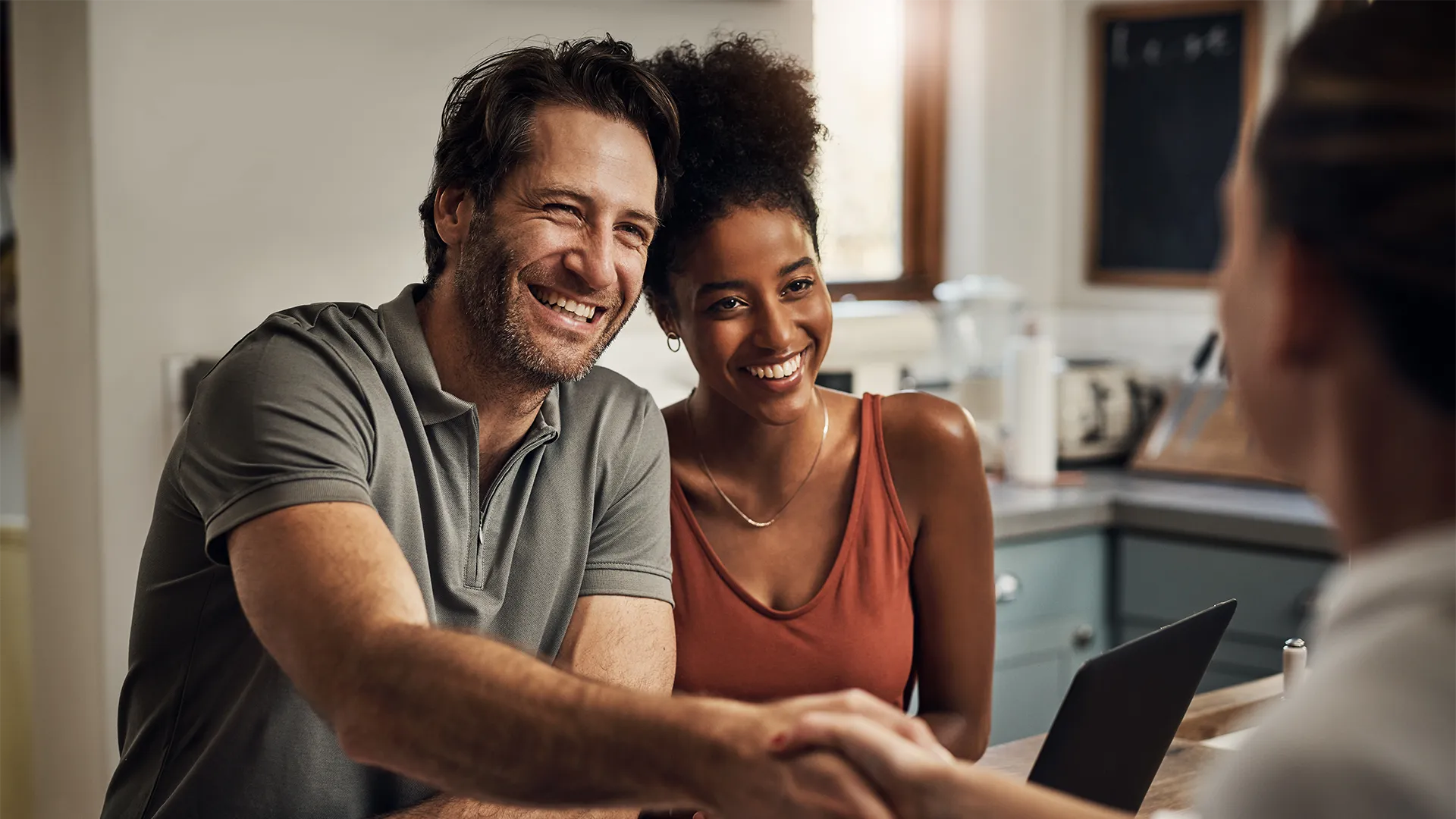 Middle-aged couple working with their financial planner and shaking hands.