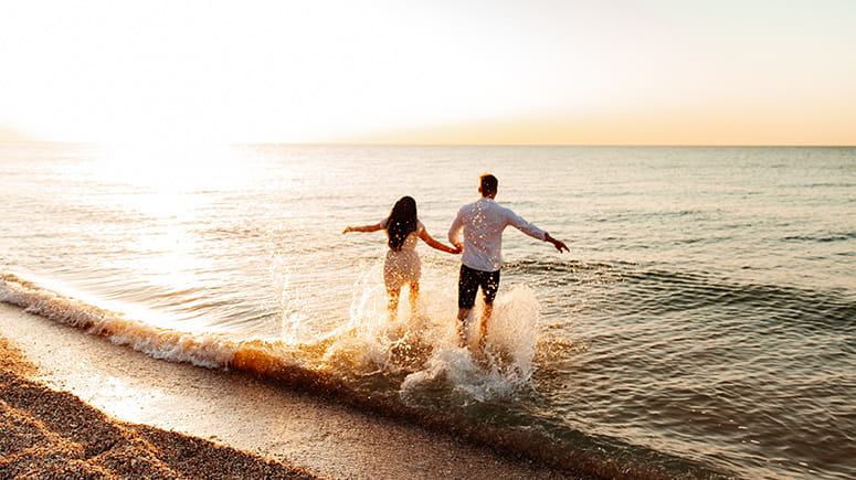 Couple dancing and playing in the water at the beach