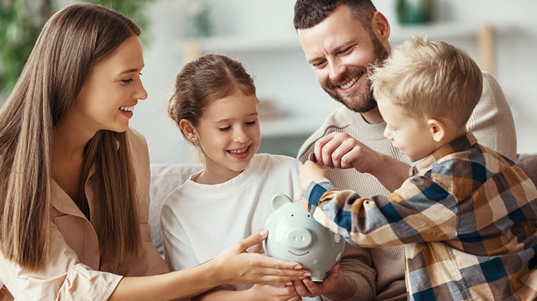 Kids put money in a piggy bank with their parents