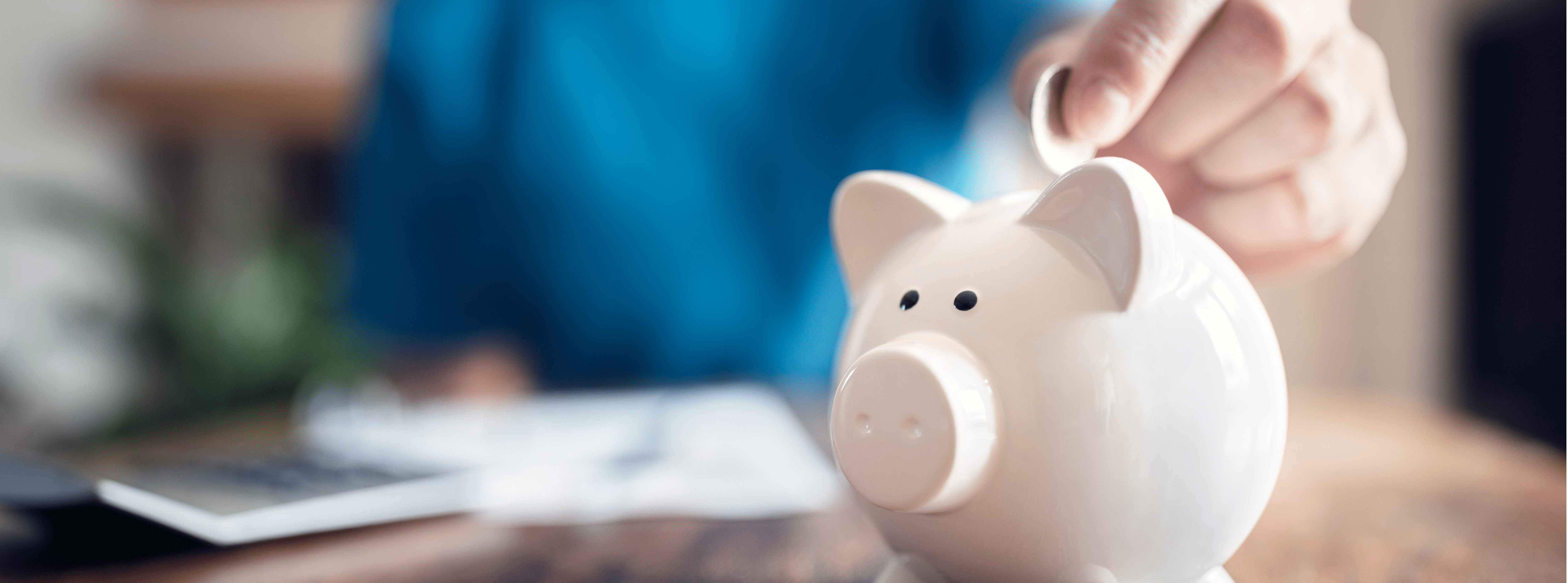 a person placing a coin in a piggybank