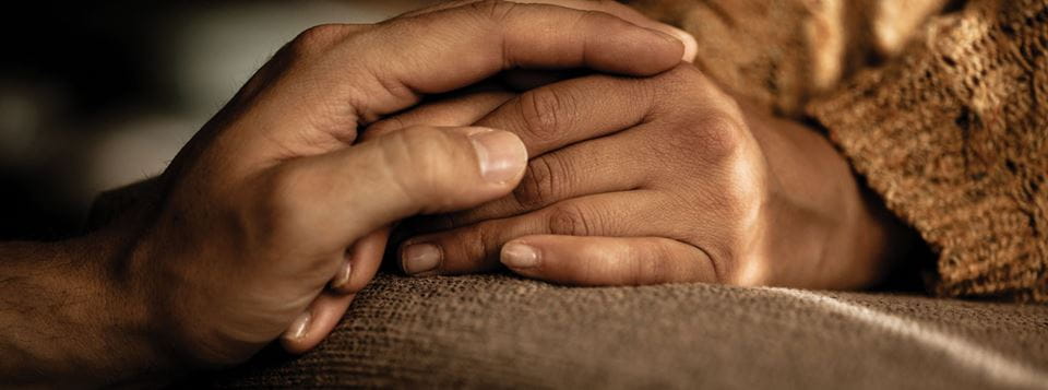 Adult holding kids hand supportively.