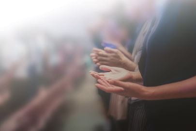Person holding their hands up in praise at church.