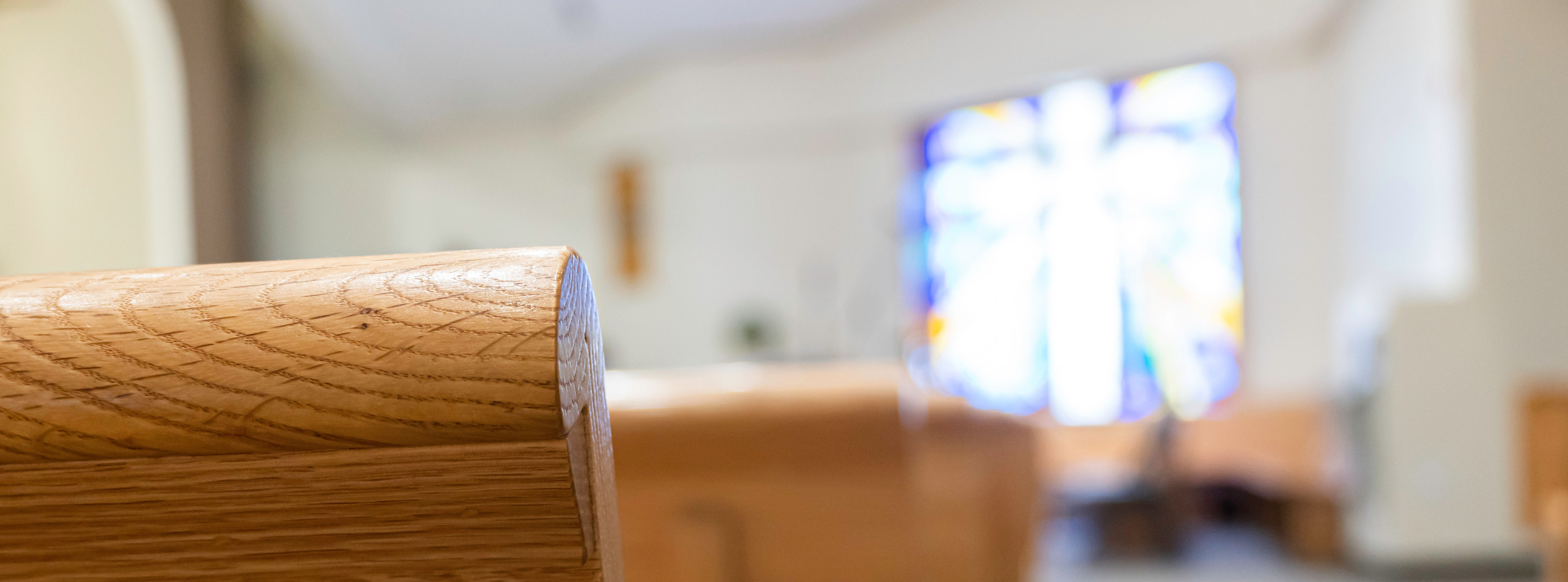 Church pews with light streaming in through stained glass window