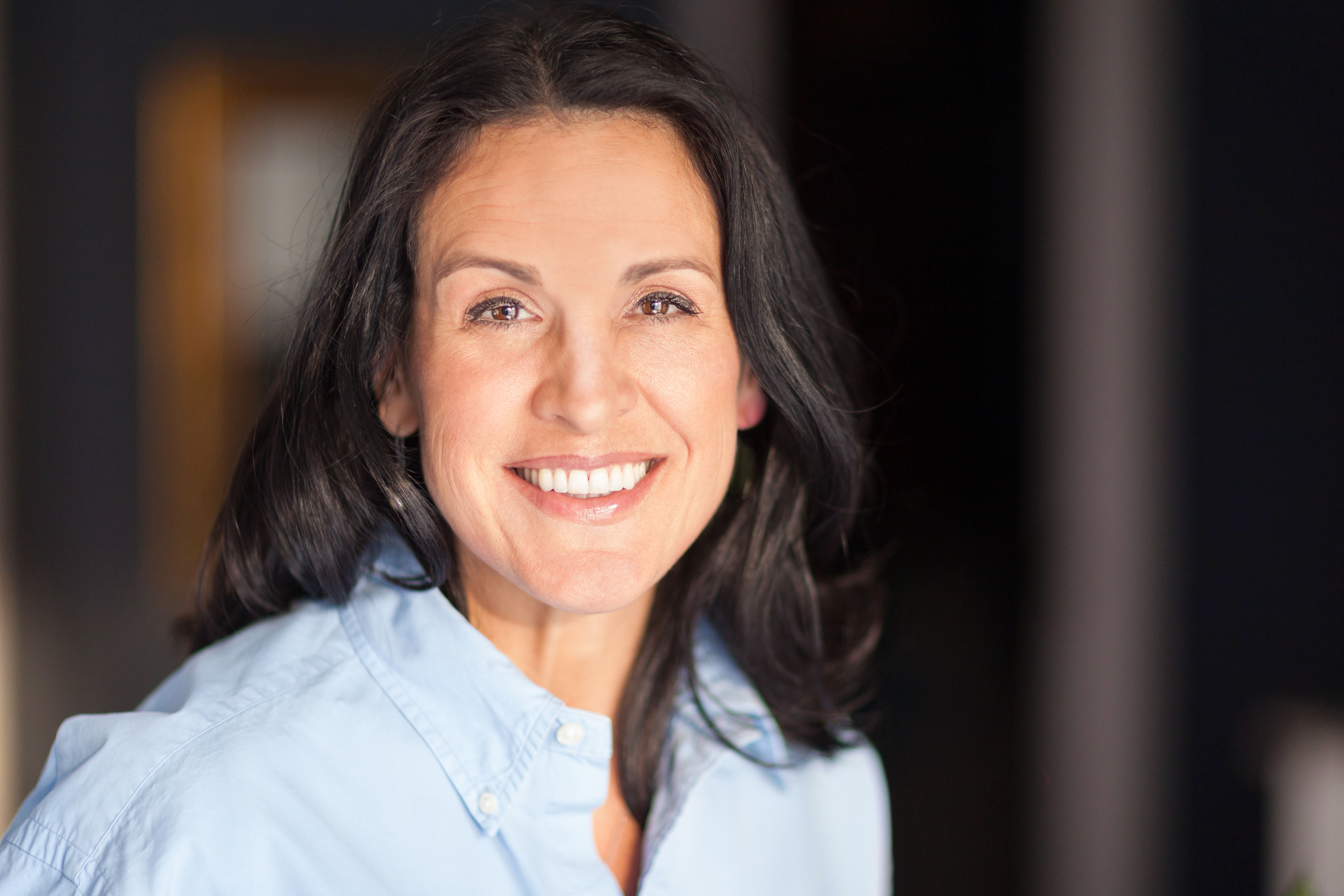 65 year old woman on Medicare Advantage with dark hair smiling at camera