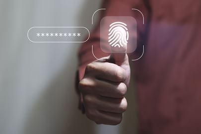Man with thumb against a security thumb scanner and password astericks