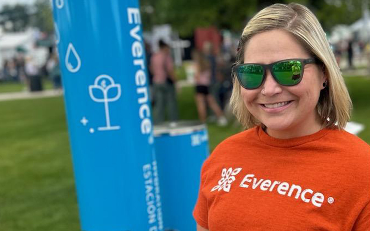 Everence employee, Amy Obarsky, stands in front of new hydration and misting station at the Elkhart County 4-H Fair.
