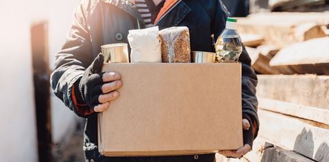 Person carrying a donated box of food for disaster relief.