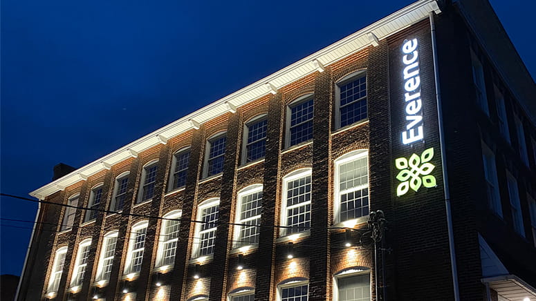 Exterior of Souderton, Pennsylvania office building at nighttime with lights lit and Everence logo lit | Everence Financial, faith-based financial services