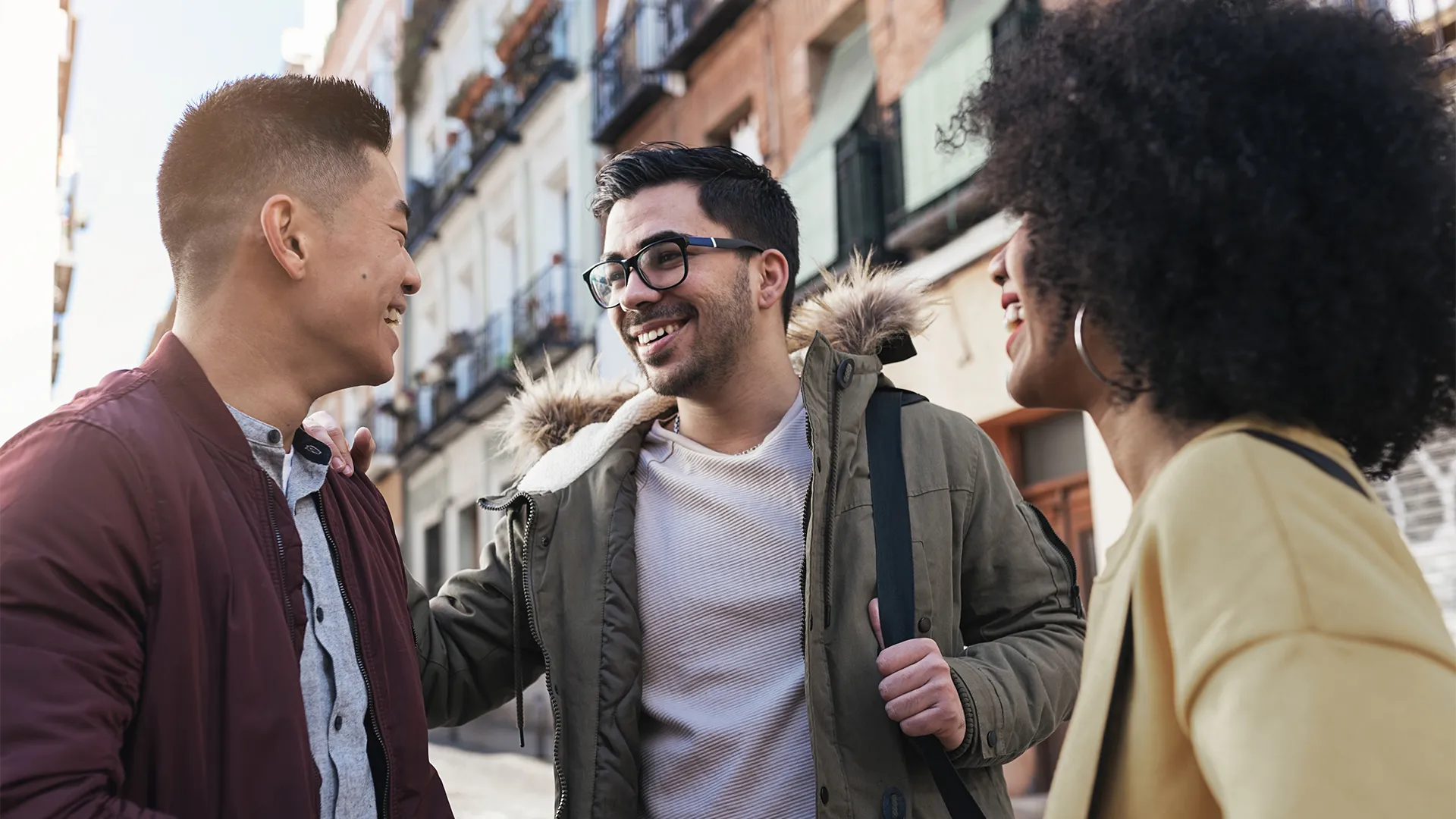 A group of individuals standing in an open urban area smiling. 