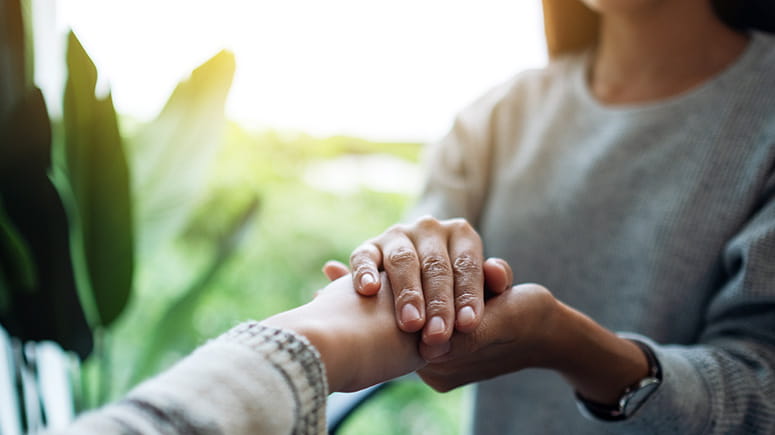 Woman holding an extended hand compassionately.