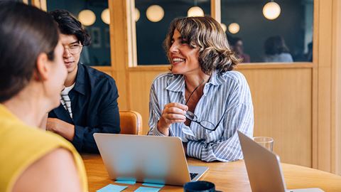 Smiling team members discussing ideas in a church meeting atmosphere