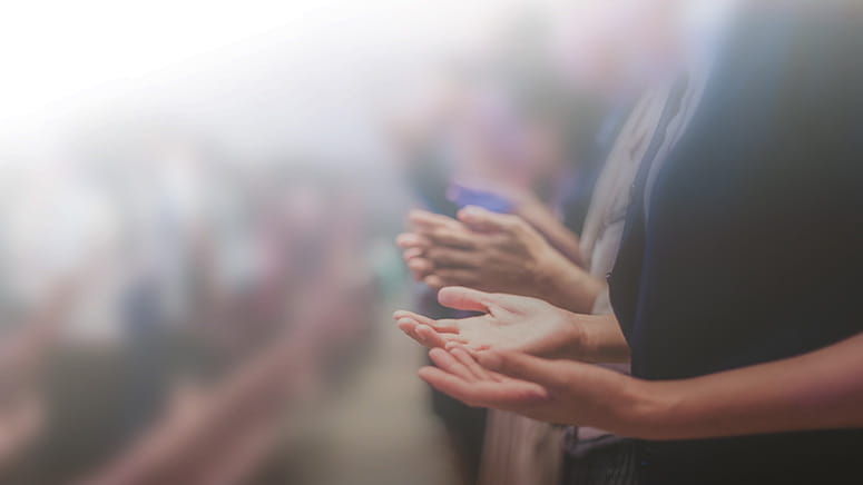Hands of church goers lifted in prayer